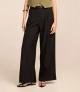 Pantalón wide leg negro de poliéster y elastano, con trabillas en la cintura, cinturón con hebilla y pliegues. Estilo sastrero.