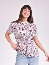 Remera estampada con motivos florales en tonos naranja, beige, gris y rosa.