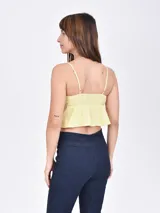 Musculosa color amarillo con breteles finos y escote con lazo.