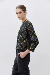 Saco corto negro con estampado geométrico multicolor, de corte recto y mangas 3/4.