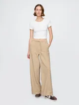 Pantalón de jean color beige, corte holgado, con cintura alta y cordón ajustable.