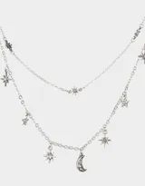 Collar corto de tres hileras con cadena de eslabones plateada. La hilera superior tiene pequeños dijes de estrellas, la hilera del medio es una cadena simple y la hilera inferior tiene dijes colgantes de estrellas y una luna creciente.