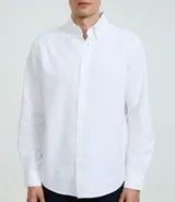 Camisa celeste de corte regular, confeccionada en tejido Oxford de algodón. Tiene cuello inglés, mangas largas y cierre frontal abotonado.