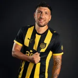 Camiseta de fútbol Puma del Club Atlético Peñarol, modelo Home, con franjas verticales amarillas y negras. Incluye logo Puma y escudo del club con cinco estrellas.