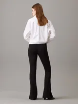 Leggings negros de punto milano con talle alto, corte slim, pierna acampanada y bajo abierto. Confeccionados con un 66% de viscosa, 30% de nailon y 4% de elastano.