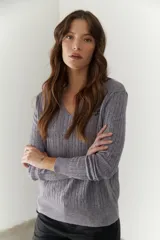 Sweater de punto marrón con escote en V y mangas largas.