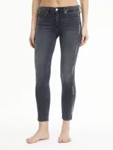 Jeans skinny de tiro medio color gris oscuro, con cierre de cremallera y botón, bolsillos delanteros y traseros, y banda lateral con logo de Calvin Klein Jeans.