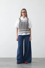 Top tejido sin mangas con diseño geométrico de rombos en relieve, en tonos azul marino y beige. Presenta escote amplio y breteles tejidos.