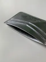 Tarjetero dorado de cuero vacuno con cuatro divisiones para tarjetas y un bolsillo central.