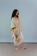 Ruana de lana merino color beige, tejida a mano con detalles de brillos y flecos.