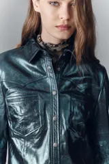 Camisa entallada de cuero ovino verde metalizado, con cuello camisero y botones a presión con logo.