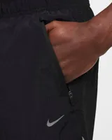 Short de running Nike Running Division, color negro, con short interior gris. Cuenta con tecnología Dri-FIT, tejido Ripstop repelente al agua, bolsillos laterales y trasero con cremallera, y bolsillo interior.
