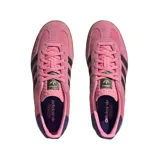 Championes Adidas Gazelle Indoor color rosa con las tres tiras laterales en negro y suela de goma color caramelo.