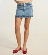 Minifalda de denim azul claro con cintura media, trabillas, bolsillos y cierre frontal con botón y cremallera.