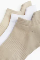 Pack de tres pares de medias deportivas tobilleras, confeccionadas en tejido funcional DryMove™ que absorbe la humedad. Incluye un par color beige, un par blanco y un par color arena. Cuentan con secciones de ventilación en malla, soporte de arco y secciones reforzadas en punta y talón.