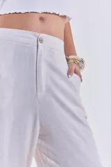Pantalón de lino color beige, de corte recto y tiro alto, con cierre de botón y cremallera.