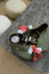 Bolso negro tipo tote de neopreno con bolsillo interno de red, sobre haciendo juego y gancho para sujetarlo.