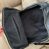 Mochila negra de cuero vacuno con forro de gabardina de algodón, compartimento acolchado para laptop de hasta 14 pulgadas, bolsillo frontal con cierre y cierres metálicos plateados.