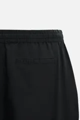 Pantalón azul marino de corte amplio, confeccionado en tejido de mezcla de algodón y lino. Cuenta con cintura elástica ajustable con cordón, bolsillos frontales y bolsillos traseros de vivo.