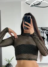 Top de malla negra, con manga larga y ajuste al cuerpo, ideal para looks atrevidos.