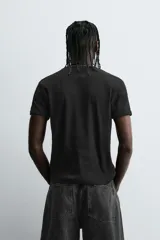 Camiseta negra de corte slim fit, cuello redondo y manga corta. Confeccionada en tejido de algodón con elasticidad y acabados en rib.