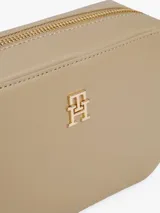 Bandolera Tommy Hilfiger color beige con logo dorado en el frente.