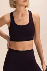 Top deportivo de lycra color morado, de impacto medio, con breteles anchos y banda elástica en el bajo busto.