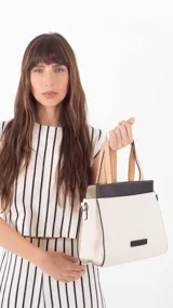 Cartera color beige con doble asa corta y correa larga extraíble. Tiene un bolsillo principal con cierre y varios bolsillos interiores.