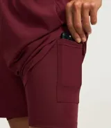 Bermuda deportiva color bordó, confeccionada en poliéster, con cintura elástica, cordón interno ajustable y short de compresión incorporado.