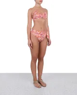 Calzón de bikini de tiro alto con estampado floral en tonos rosa, naranja y blanco. Presenta un lazo decorativo en un lateral.
