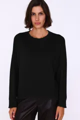 Sweater negro de corte holgado con cuello redondo y terminaciones desflecadas.