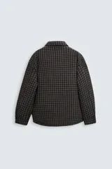 Sobrecamisa de hombre con corte relaxed fit, confeccionada en tejido de algodón acolchado con estampado a cuadros en tonos marrón, negro y beige. Tiene cuello solapa, manga larga con puños abotonados, bolsillo tipo parche en el pecho, aberturas laterales en el bajo y cierre frontal con botones a presión.