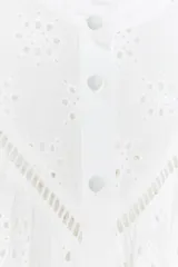 Camisa blanca de manga larga con cuello con volantes y bordados perforados. Cierre frontal con botones a tono.