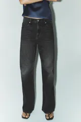 Jeans de tiro medio color azul oscuro, corte wide leg, con trabillas y cinco bolsillos. Cierre frontal con cremallera y botón metálico.