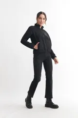 Campera negra de corderito con cierre frontal y cuello alto. Tiene un bolsillo con cierre en el pecho y bolsillos laterales.