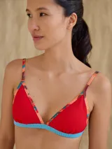 Top de bikini rojo de triángulos con tirantes finos y contorno inferior a rayas horizontales celestes y blancas.