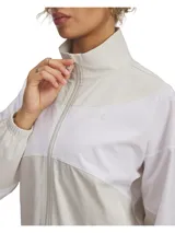 Campera deportiva Under Armour Rival Woven para mujer, color lila y blanco, con cierre frontal, cuello alto y logo bordado en el pecho.