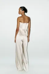 Pantalón de vestir color crema, de tela satinada, tiro alto y corte palazzo.
