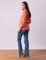 Blusa blanca de poliéster y rayón con escote en V bordado y mangas tres cuartos regulables con presilla y botón.