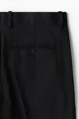 Pantalón de vestir negro de corte recto, con cierre frontal, pretina con botón, bolsillos laterales y traseros ribeteados con botón.