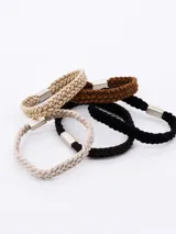 Pack de cinco coleros de pelo tejidos en crochet, en tonos beige, marrón y negro.