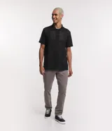 Pantalón de vestir marrón, de corte skinny, con bolsillos laterales y traseros. Se ajusta a la cintura con cinturón de cuero marrón.