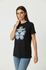 Remera negra de manga corta con estampado de mariposa azul y texto "Set Yourself Free".