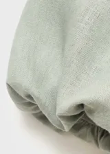 Vestido midi verde oliva de lino, con escote off-shoulder y mangas cortas abullonadas. Tiene corte evasé y cierre de cremallera en la espalda.