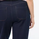 Pantalón de jean de mezclilla oscura, corte wide leg con tiro alto y grandes bolsillos cuadrados visibles en la parte delantera. Presenta dobladillos anchos en los tobillos.