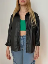 Sobrecamisa oversize de ecocuero color negro, con bolsillo delantero y puños ajustables.