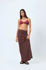 Falda larga tejida color crema, con trama calada de punto abierto y cordón ajustable en la cintura.