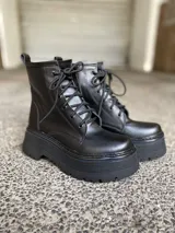 Borcegos negros de cuero sintético con plataforma y cordones.