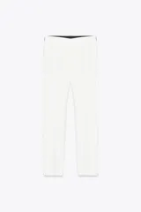 Pantalón blanco tobillero de tiro medio con cintura elástica en la espalda, bolsillos delanteros y falsos bolsillos de vivo en la espalda. El bajo está acabado con aberturas laterales.
