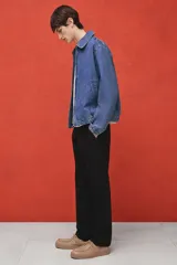 Pantalón de vestir negro con pliegues, corte recto y bolsillos laterales.